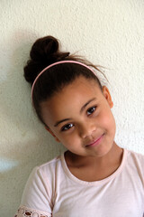Fototapeta premium Cute girl daughter with top bun expression content smile