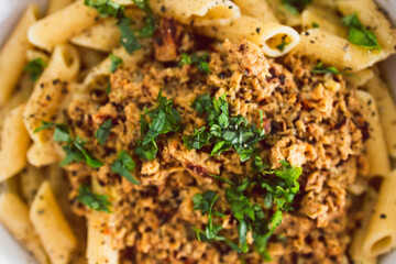 vegan penne pasta with plant-based meat and lemon sauce, healthy plant-based food