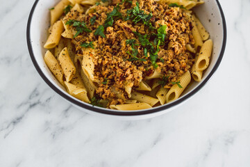 vegan penne pasta with plant-based meat and lemon sauce, healthy plant-based food