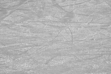 Surface of an outdoor ice rink replete with skate marks
