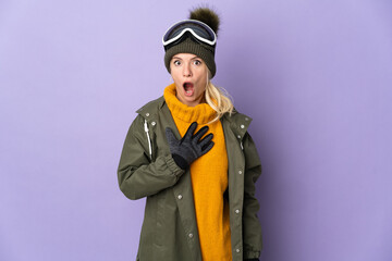 Skier Russian girl with snowboarding glasses isolated on purple background surprised and shocked while looking right