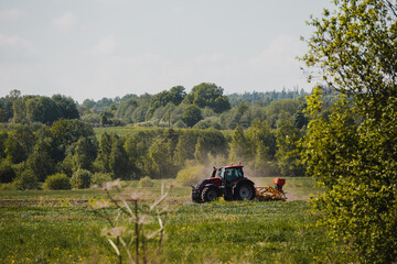  tractor driving trough a farm field in summer © Andris