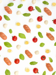 Abstract background of basil leaves, cherry tomatoes and sausages