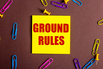 The words GROUND RULES is written in red on a yellow sticker on a brown background next to...