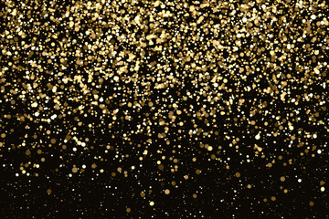 Blurred luminous golden particles on black background