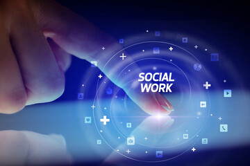 Finger touching tablet with social media icons and SOCIAL WORK