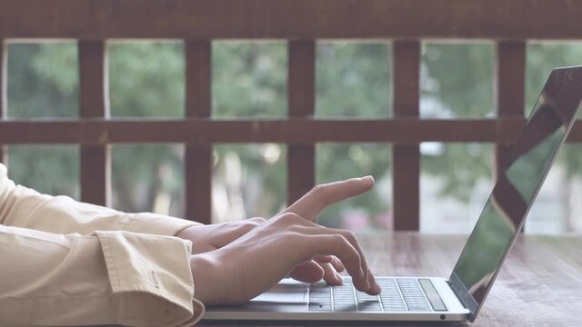 Close-up of a woman's hand opening her laptop and pressing the keyboard with her finger, Activities of office workers that require a laptop to work.