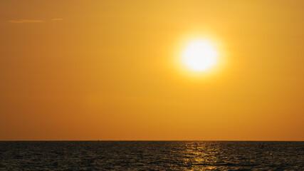 golden sunset or sunrise at the deep dark ocean. aerial view of sundown and up to the sea. yellow and orange colorful sky. romantic beautiful sky in the spring season. heavenly sky. new beginning