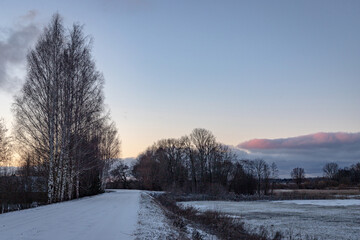 Fototapeta na wymiar Beautiful orange blue sunset over a snowy road. Winter landscape.