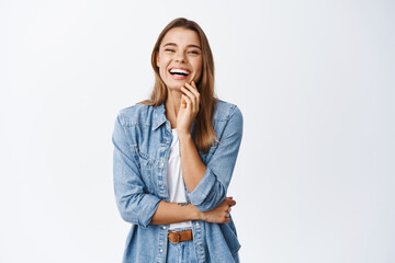 Portrait of happy blond woman in casual clothes, laughing and having fun, smiling cheerful at camera, standing against white background - 418694965
