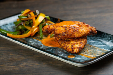 deep-fried chicken wings with grilled vegetables. chicken steak with vegetables. green beans and grilled peppers with chicken thighs with tomato sauce