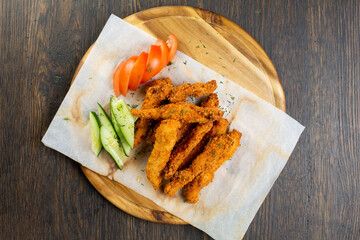 deep-fried chicken nuggets breaded with fresh cucumber and tomato. beer snack. view from above