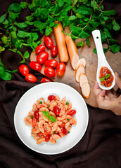 Top view macaroni pasta with tomato sauce, pork and vegetables.