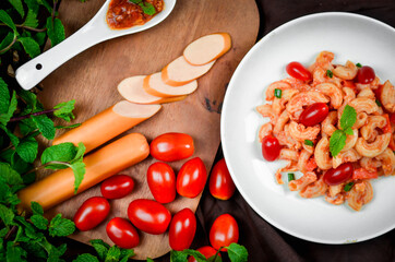 Top view macaroni pasta with tomato sauce, pork and vegetables.