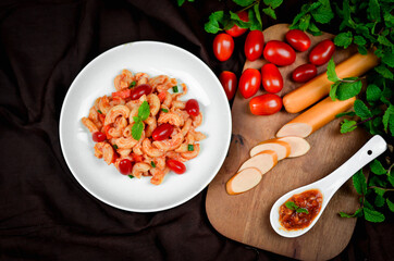 Top view macaroni pasta with tomato sauce, pork and vegetables.