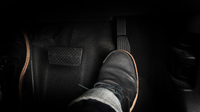 Accelerator and breaking pedal in a car. Close up the foot pressing foot pedal of a car to drive ahead. Driver driving the car by pushing accelerator pedals of the car. inside vehicle. 
