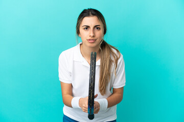 Young caucasian woman isolated on blue background playing tennis