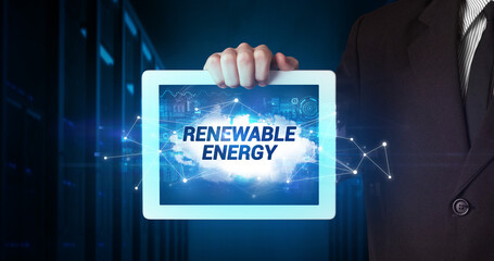 Young business person working on tablet and shows the inscription: RENEWABLE ENERGY