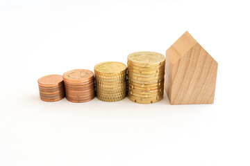 home buying concept. Coins and wooden models of houses represent financial growth, real estate financing and investing in real estate.