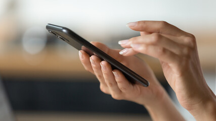 Close up of young woman user hands hold new modern gadget digital smartphone use internet application browse web. Cropped shot of millennial teenage female texting at social network online. Copy space