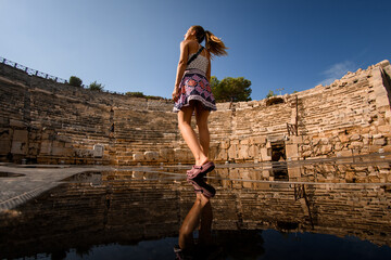 Naklejka premium woman walks at ruins of amphitheatre and assembly hall ancient Lycian city Patara.