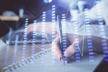 Double exposure of forex chart drawing over people taking notes background. Concept of financial analysis