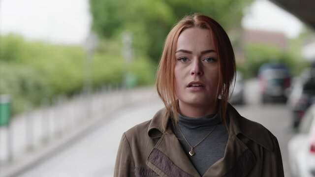 [4k] nervous beautiful young ginger woman reacting to off speaker by raising eyebrows and trying to calm down