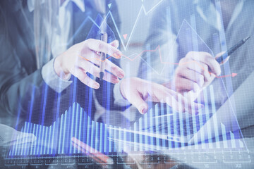 Multi exposure of man and woman working together and financial chart hologram. Business concept. Computer background.