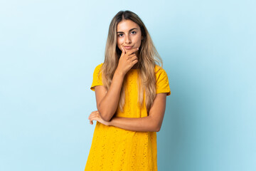 Young hispanic woman over isolated blue background thinking