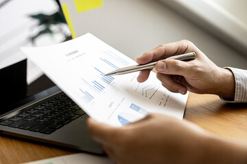 Business men are looking at the company's financial documents to analyze problems and find solutions before bringing the information to a meeting with a partner. Financial concept.