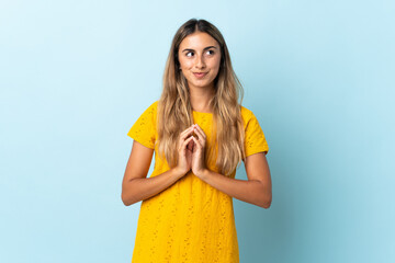 Young hispanic woman over isolated blue background scheming something
