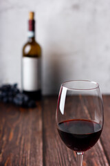 Red wine glasses and bottle on wooden background.