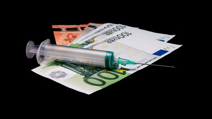 Money and syringe on dark background. Costs of medical service and vaccination expenses concept