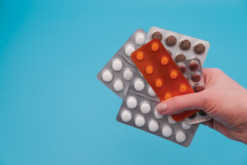 Hand holding blister pills. Pharmacy and medical treatment concept. Copy space