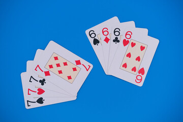 Playing cards showing seven and six for hearts, clubs, spades and diamonds on blue background. Gambling concept