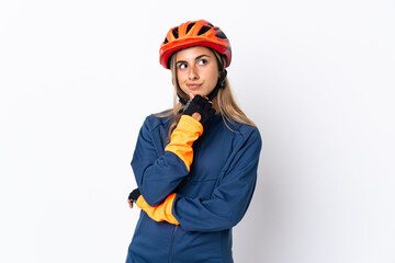 Young hispanic cyclist woman isolated on white background and looking up - obrazy, fototapety, plakaty