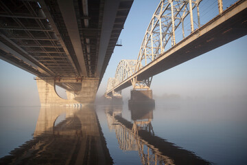 A bridge over a large river.. Fog on the river in early spring