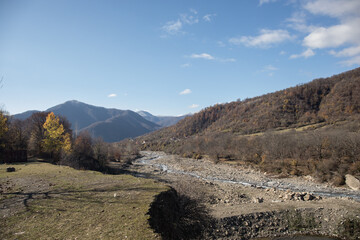 Amazing view with colorful autumn forest with asphalt mountain road at sunset.