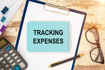 Notebook with text - Tracking expenses near office supplies.