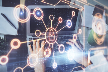 Double exposure of woman hands typing on computer and social network theme hologram drawing. People...