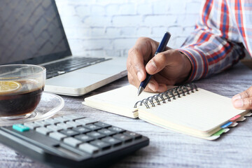 Close up of man hand writing on notepad.