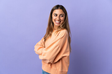 Young hispanic woman over isolated purple background with arms crossed and happy