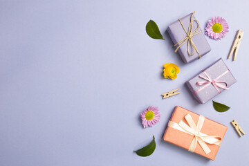 Gift boxes with flowers on purple background. anniversary concept. flat lay, top view, copy space