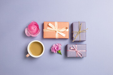 Gift boxes, cup of coffee, flowers on purple background. anniversary concept. flat lay, top view, copy space