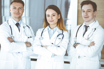 Group of modern doctors standing as a team with arms crossed in hospital office. Physicians ready to examine and help patients. Medical help, insurance in health care, best treatment and medicine