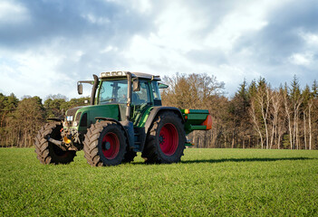 Düngerverordnung - Landwirt beim Dünger streuen auf einem Feld, landwirtschaftliches Symbolfoto.