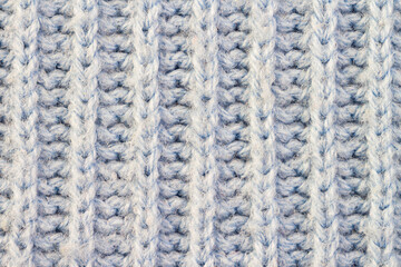 Knitted light woolen blue pattern with stripes braided surface macro