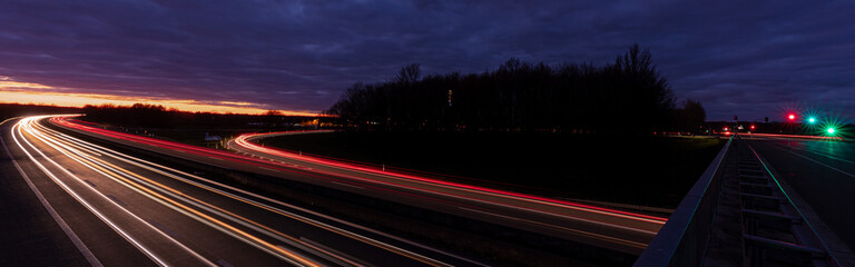 Autobahn Ausfahrt bei Nacht. Bewegung Traffic auf der Hauptstra&szlig;en. Langzeitbelichtung mit Autos
