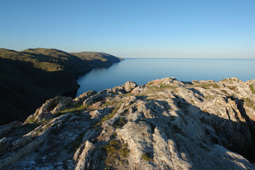 Beautiful view of Baikal Lake from the high cliffs of Cape Ulan-Zaba on a clear summer evening (area of Aya bay in Tazheranskaya or Tazheran steppe), Siberia, Russia