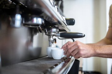 Fototapeta na wymiar Male hands putting cups into coffee machine